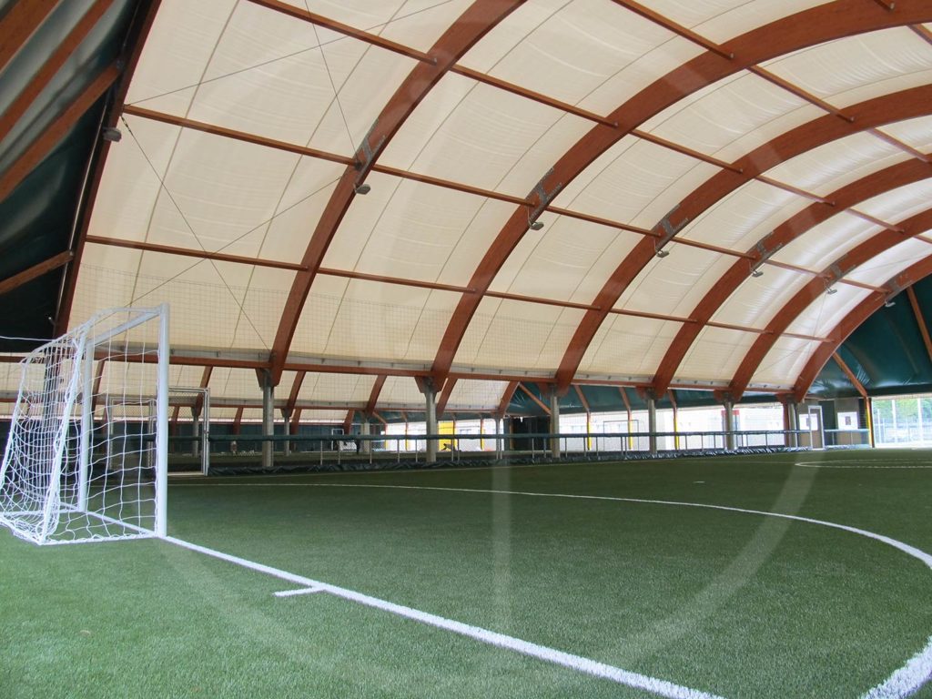 Nebeneinander angeordnete Zeltstrukturen aus Breitschichtholz für Fußballkleinfelder